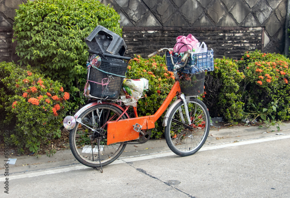 A bicycle with a load is parked on the side of the road, Thailand