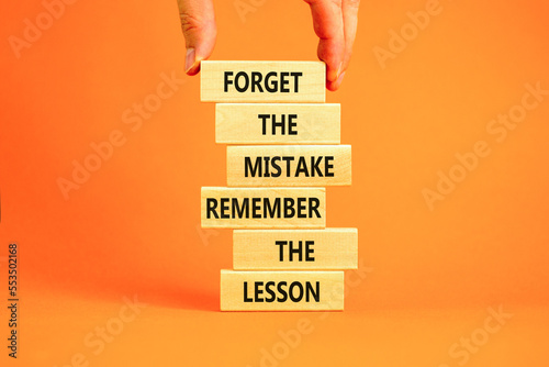 Lesson from mistake symbol. Concept words Forget the mistake remember the lesson on wooden blocks on a beautiful orange table orange background. Businessman hand. Business lesson from mistake concept. photo