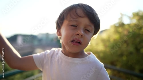 One little boy hitting own head with hand. Portrait of a child embarrassed by mistake standing outdoors. Oh no concept photo