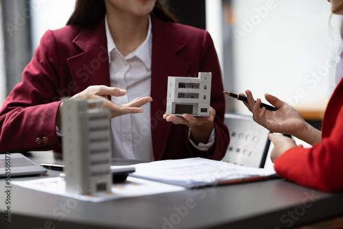 Asian businesswoman making a deal to buy a house or condo inside the office, home insurance concept