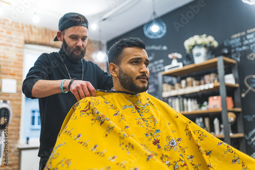 Photography The barber getting ready to cut his client at the barbershop