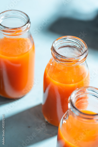 Fresh carrot, orange, apple and ginger juice in glass. 