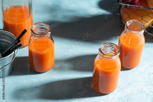 Fresh carrot, orange, apple and ginger juice in glass. 