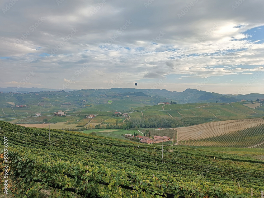two hot air balloons fly over the Barolo hills