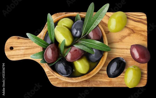 Green, black and brown olives with leaves on wooden board, isolated on black background