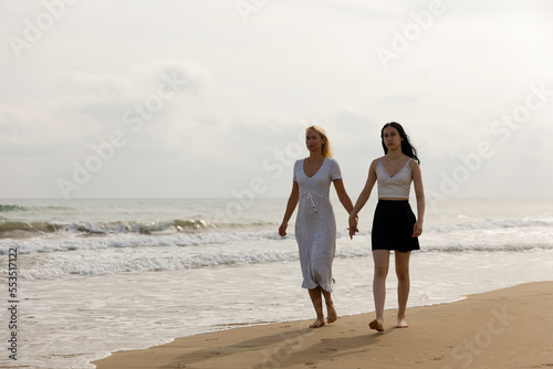 Mother and daughter walk along the seashore. Family vacation, healthy lifestyle, family leisure