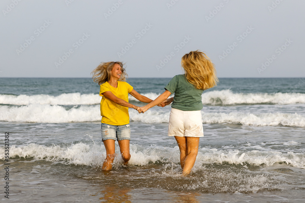 Girlfriends walk and have fun at the sea, family vacation at sea
