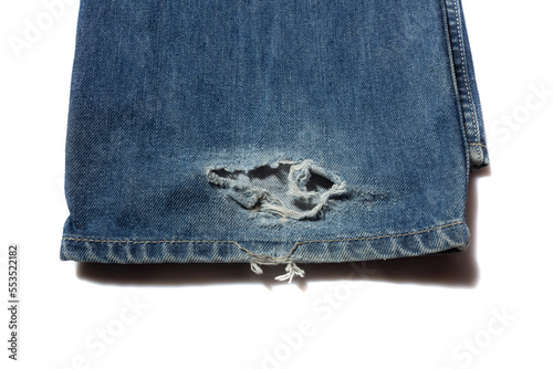 Broken blue jeans hem on white background