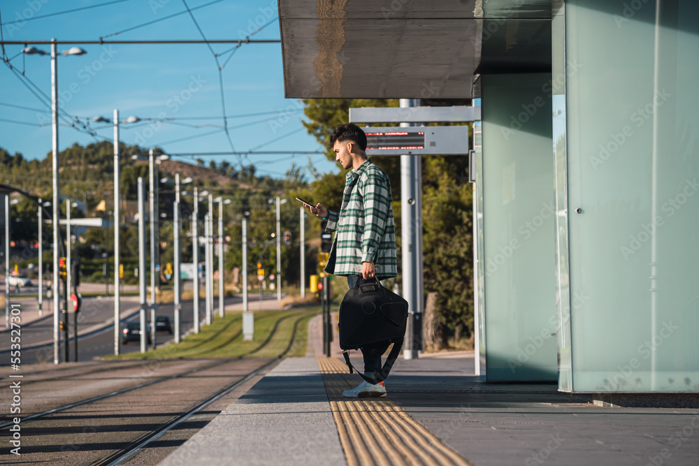 Male student waiting for the tram