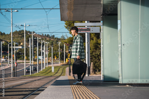 Obraz na płótnie Male student waiting for the tram w salonie