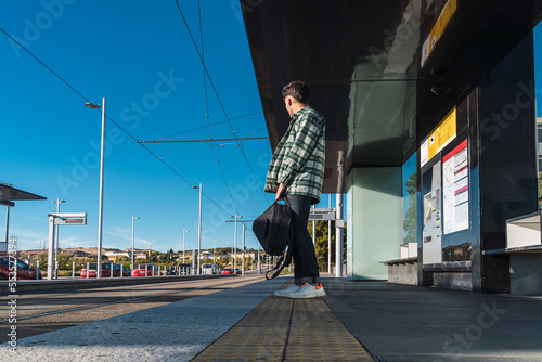 Obraz na płótnie Male student waiting for the tram w salonie