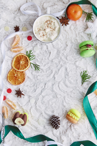 Fototapeta Naklejka Na Ścianę i Meble -  Aesthetic Christmas background with colorful sweet macaroons, winter decorations, tangerines and marshmallow cocoa