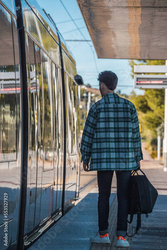 Obraz na płótnie Male student waiting for the tram w salonie