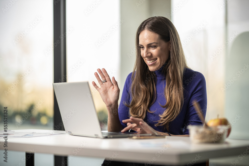 Young happy female worker in her office working on laptop Young happy female worker in her office working on laptop