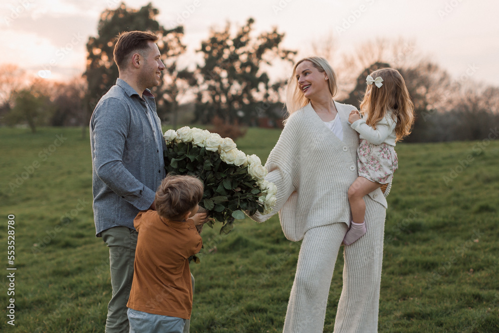 father and children congratulate mother on holiday and give flowers. father and children congratulate mother on holiday and give flowers.
