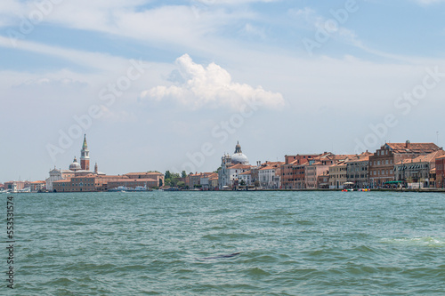 View of the Venice Canal embankment on a warm summer day, with floating boats and old houses, Venice, Italy © Irina Satserdova