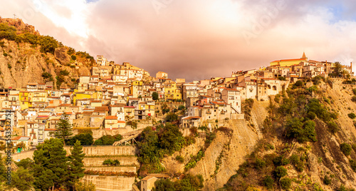 old mediterranean mountain dense town with levels of yellow houses and terraces on a mountain in evening light  vintage european village on a rock