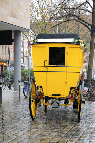 Historische gelbe Postkutsche von zwei Pferden gezogen in der Nürnberger Altstadt in der Vorweihnachtszeit 