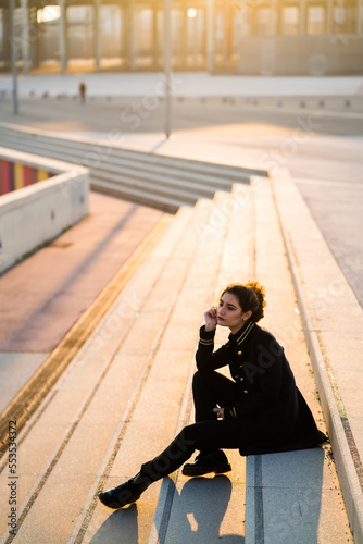 Adult young woman wearing all black sitting on stairs outdoors