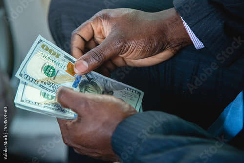 Counting paper money. Close-up of a man's hands counting dollar bills. The concept of earnings and business profitability. Benefit, profit and salary for a major purchase or acquisition,