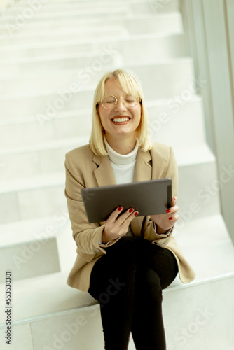 Businesswoman with digital tablet on modern office stairs