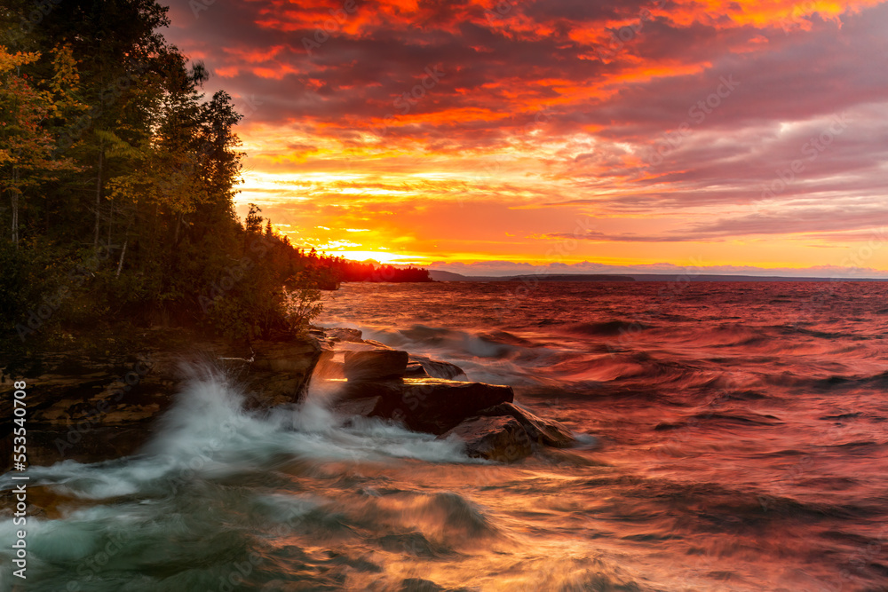 Vivid Sunset over Lake Superior. Sun reflects on the waters as waves crash into an inlet