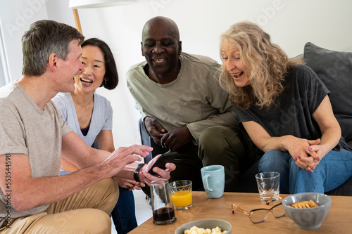 Group of diverse middle age friends having a good time at home