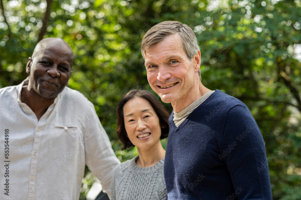 Portrait of middle age diverse group of friends gathered at public park