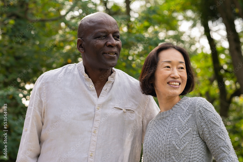 Middle-aged diverse couple hanging out inpublic park Middle-aged diverse couple hanging out inpublic park
