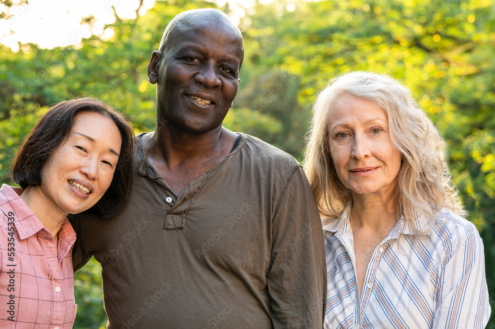 Diverse group of senior male and female friends posing for photo ourdoors