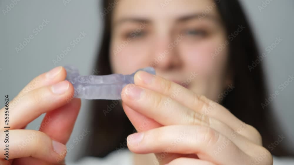 Woman puts in her mouth dental mouthguard, splint for the treatment of