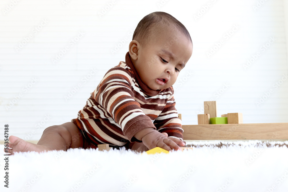 Portrait of adorable six month crawling African American baby playing with wooden developmental toys on fluffy white rug, happy sweet little girl kid learning, childhood and baby care concept. Portrait of adorable six month crawling African American baby playing with wooden developmental toys on fluffy white rug, happy sweet little girl kid learning, childhood and baby care concept.