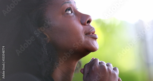 African woman praying to God seeking divine help, asking for support
