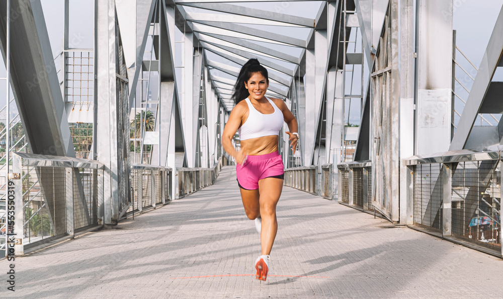 Adult woman running on the bridge of the maritime city