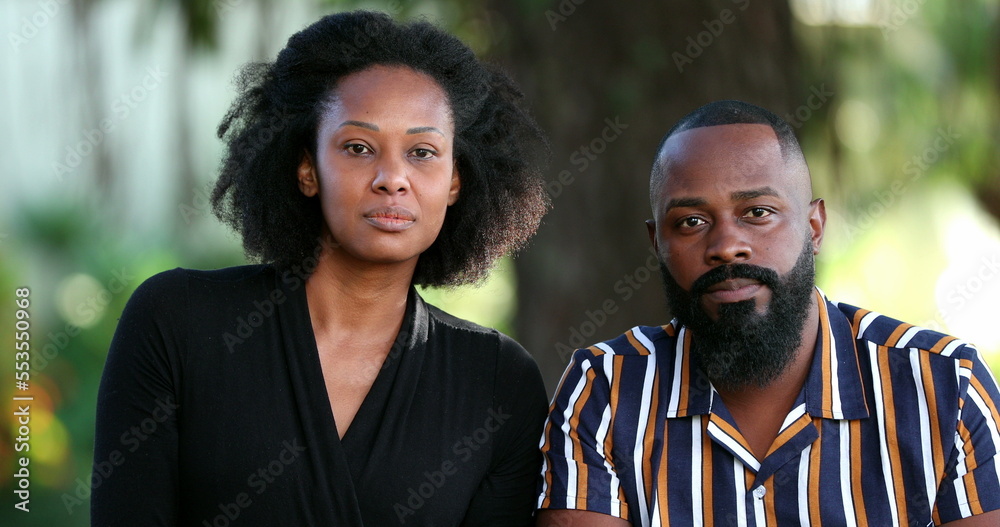 African couple staring at camera outside. Black man and woman outdoors African couple staring at camera outside. Black man and woman outdoors