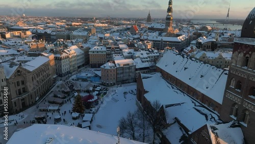 Beautiful winter wonderland over Riga old town. Christmas market with Christmas tree in the center of the city. Magical holiday spirit in Europe. Aerial view.