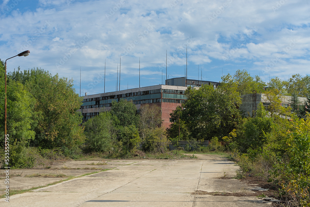 Abandoned industrial building overgrown with trees Abandoned industrial building overgrown with trees