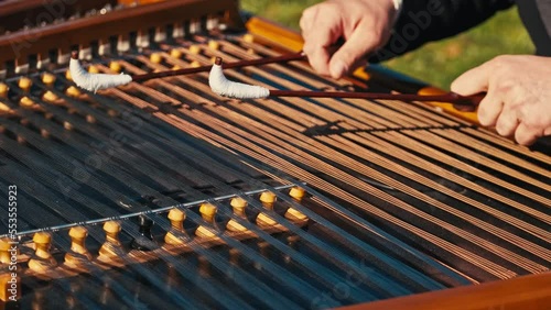 Close up footage of musician playing at cimbalom musical instrument outdoor. photo