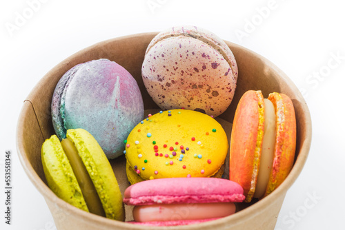 Colorful macaroons or macaron in a cardboard box isolated on white background close up. Tasty colorful macaroons. French pastry made from egg whites. Culinary and cooking concept.