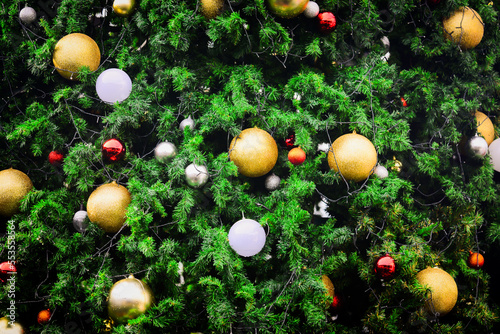 Background for Christmas season. Close-up shot of a beautiful decorated fir tree.