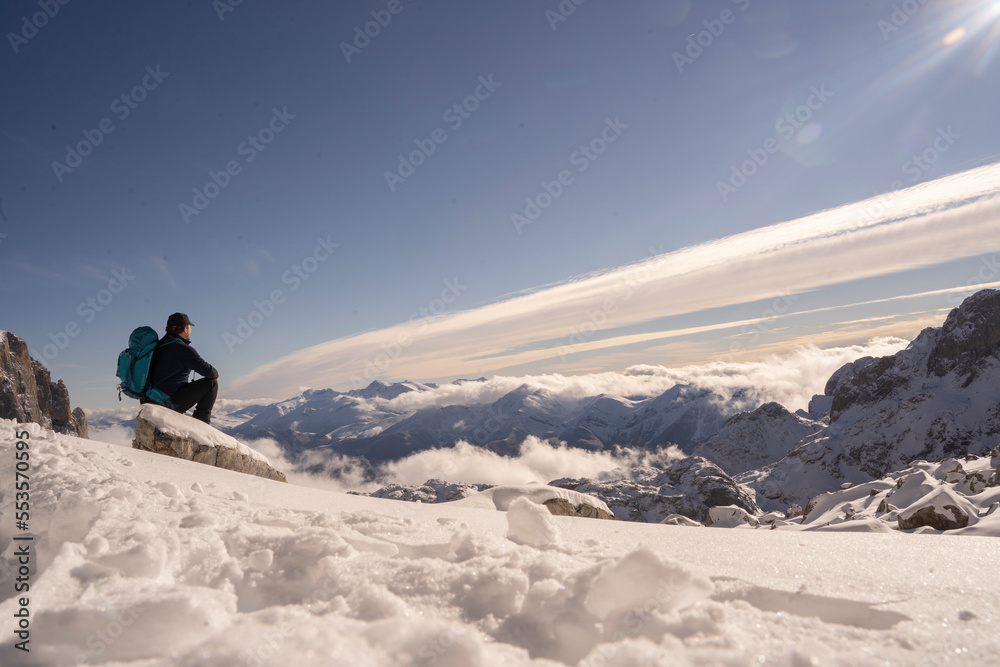 alpinist  resting on the top of a mountain covered of snow in winter 