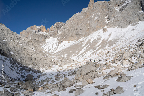 three alpinists clibing a snowy mountain in winter photo
