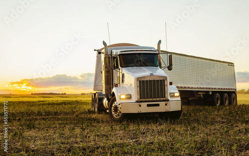 Transport truck in a canola field at sunset during harvest; Legal, Alberta, Canada photo