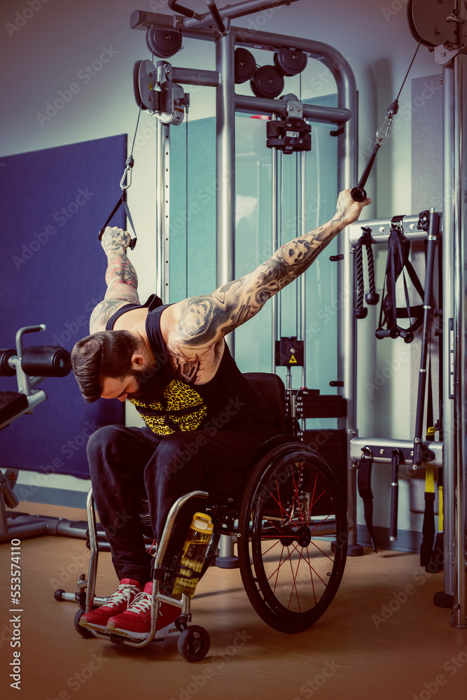 A paraplegic man working out using a crossover pulley weight lifting