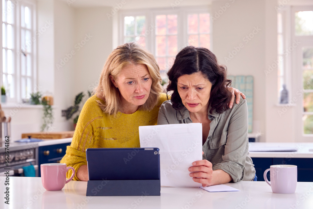 Same Sex Mature Female Couple Using Digital Tablet At Home To Check Domestic Finances Same Sex Mature Female Couple Using Digital Tablet At Home To Check Domestic Finances