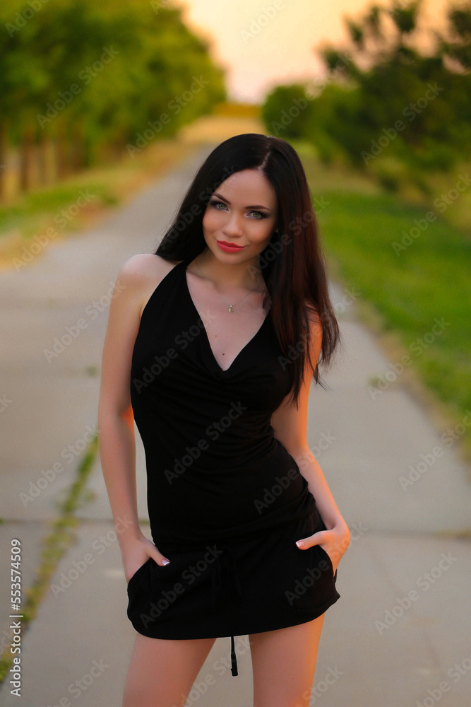 beautiful nice fashion brunette girl posing in the park in black dress and shoes and big breasts beautiful nice fashion brunette girl posing in the park in black dress and shoes and big breasts