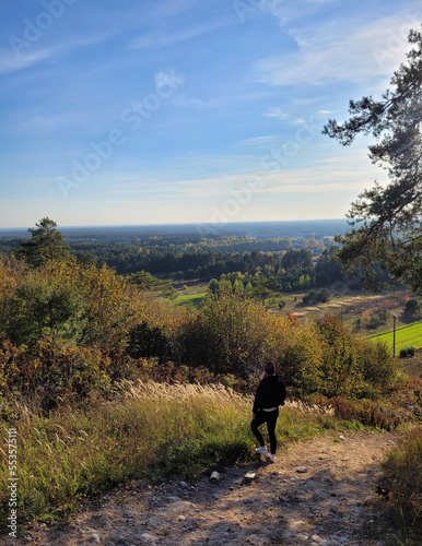 Kobieta podróżniczka jesienią na wzgórzu, Roztocze na Lubelszczyźnie. © Adam Sadlak