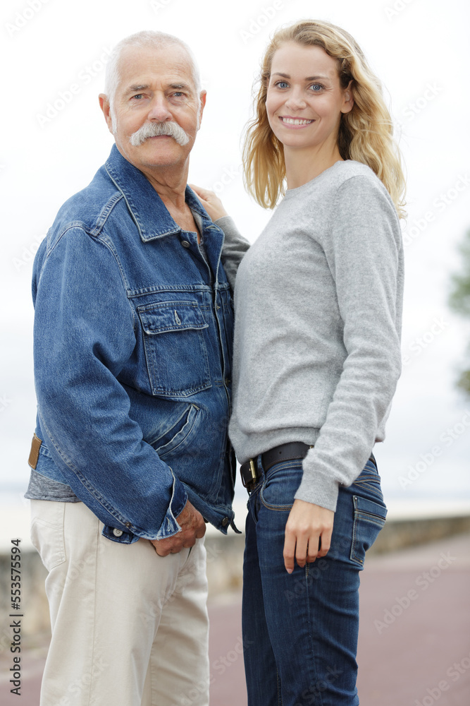 portrait of happy senior man and his adult daughter outdoors