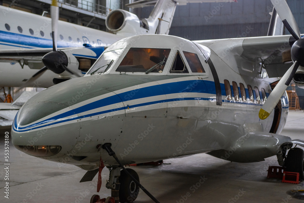 A turboprop aircraft is in the hangar for maintenance. Selective focus.