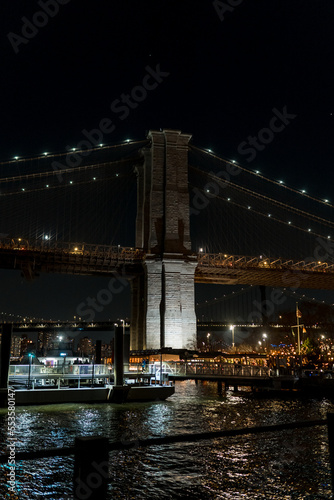 Brooklyn Bridge in New York at night. Skyscrapers of a large metropolis. Night city at long exposure. Towers in the big city.